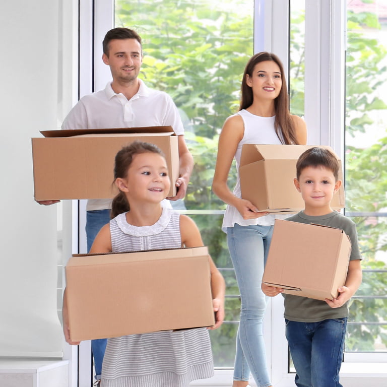 Une famille apporte des boites dans leur nouvelle maison.